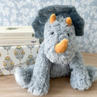 Gray plush triceratops toy with orange horns and nose.