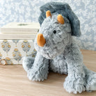 Gray, plush dinosaur toy with orange horns.