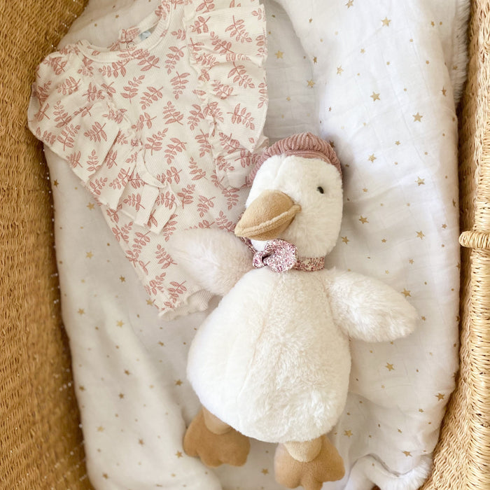 Top, toy goose, blanket in wicker basket.