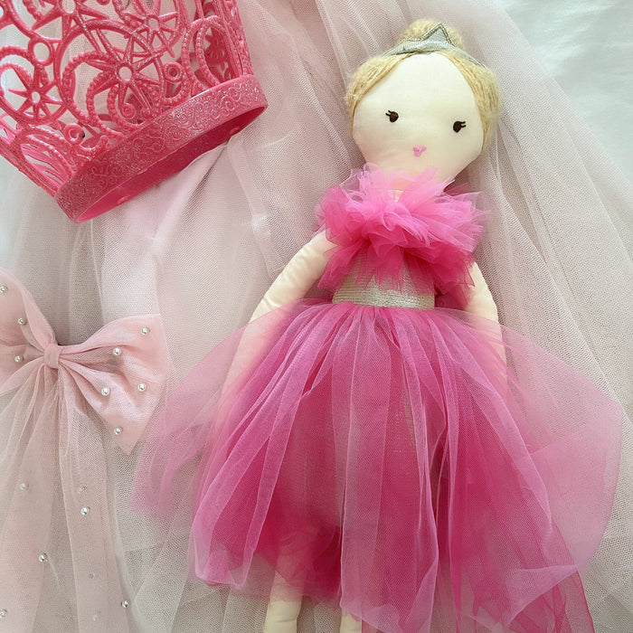 Stuffed doll wearing a pink tulle dress, pink crown, and bow.