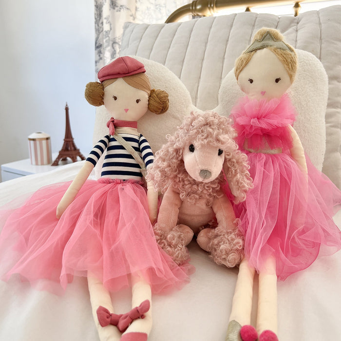 Three stuffed toys: two dolls with pink tulle dresses and a pink poodle.