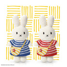 Two knitted Miffy rabbits, one in blue and white stripes and one in red and white stripes, against a yellow line background.