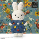 Crocheted Miffy rabbit doll in a floral-themed blue dress, against a Van Gogh-inspired backdrop.