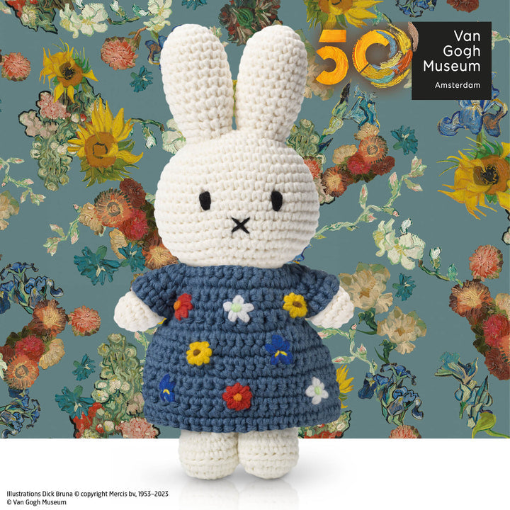 Crocheted Miffy rabbit doll in a floral-themed blue dress, against a Van Gogh-inspired backdrop.