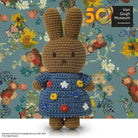 Crocheted bunny in blue floral dress, Van Gogh Museum backdrop.