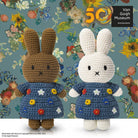 Two crocheted Miffy rabbit dolls in blue floral dresses against a floral background.