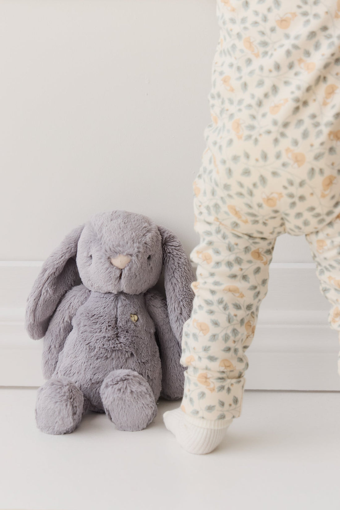 Gray plush bunny and baby in patterned leggings.