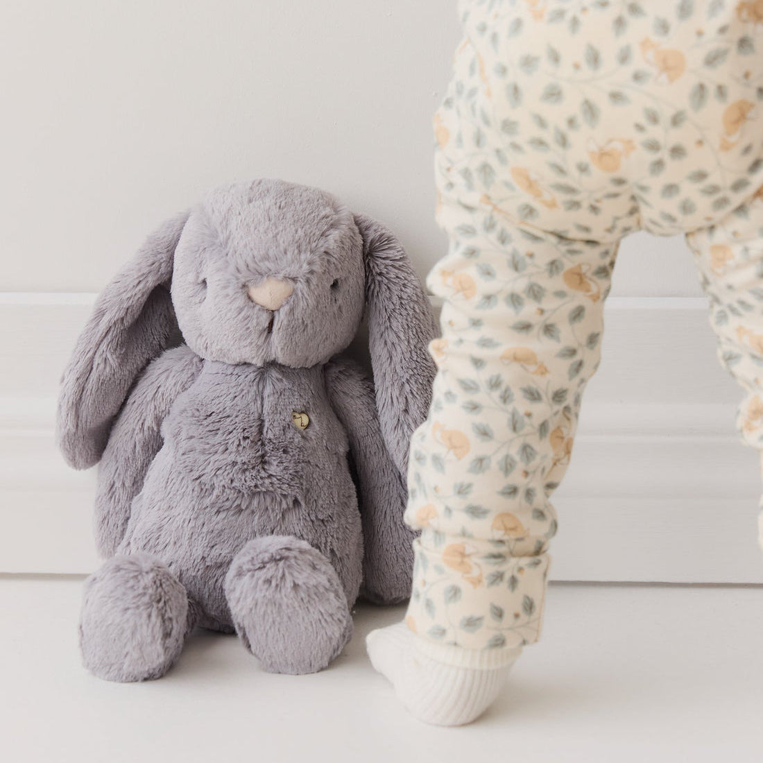 Gray plush bunny and baby in patterned leggings.