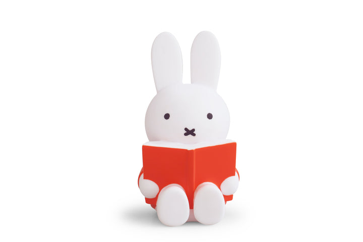 White Miffy lamp reading red book.