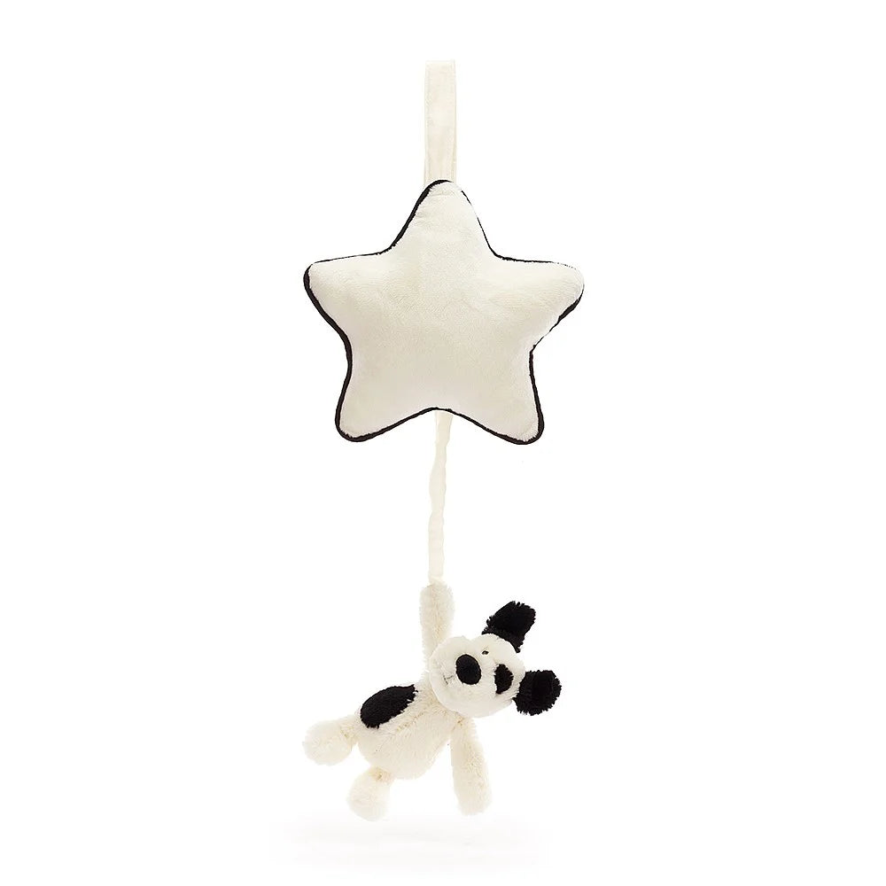 Stuffed white star with black trim hanging above stuffed white and black cow.