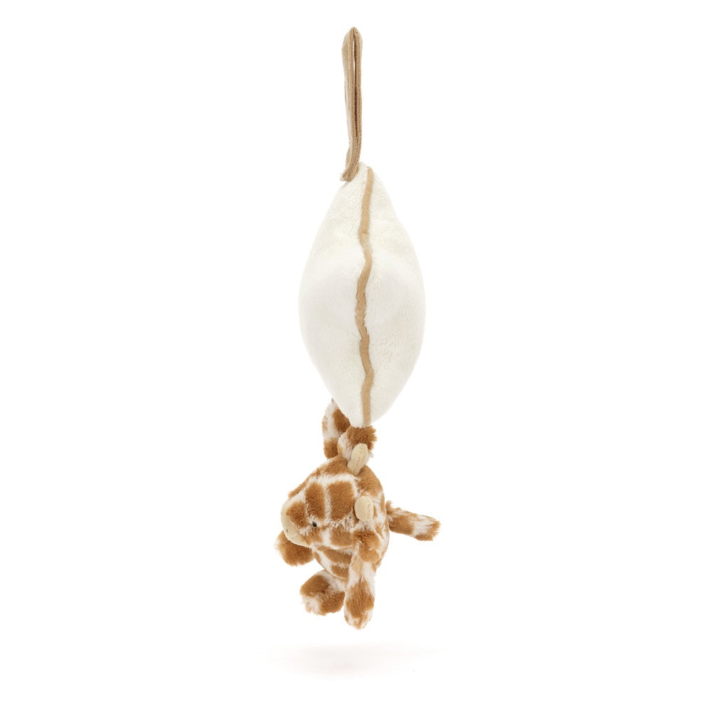 Stuffed giraffe hanging from a cream-colored toy.