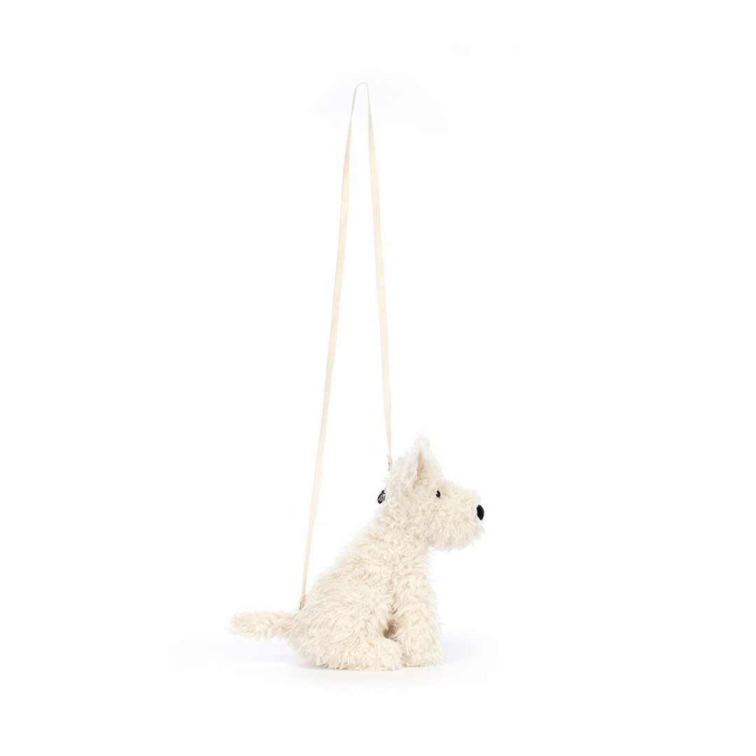 Side profile of a stuffed white Westie dog purse with a beige strap.