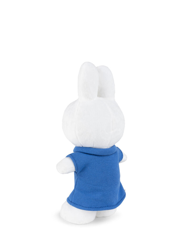 Back view of a plush white rabbit wearing a blue shirt.