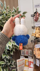 A white and blue plush Miffy keychain with tags.