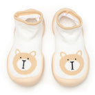 Two white baby socks with tan bear design.