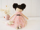 Handmade doll in a pink tulle dress with gold stars, sitting next to a star wand and flower arrangement.