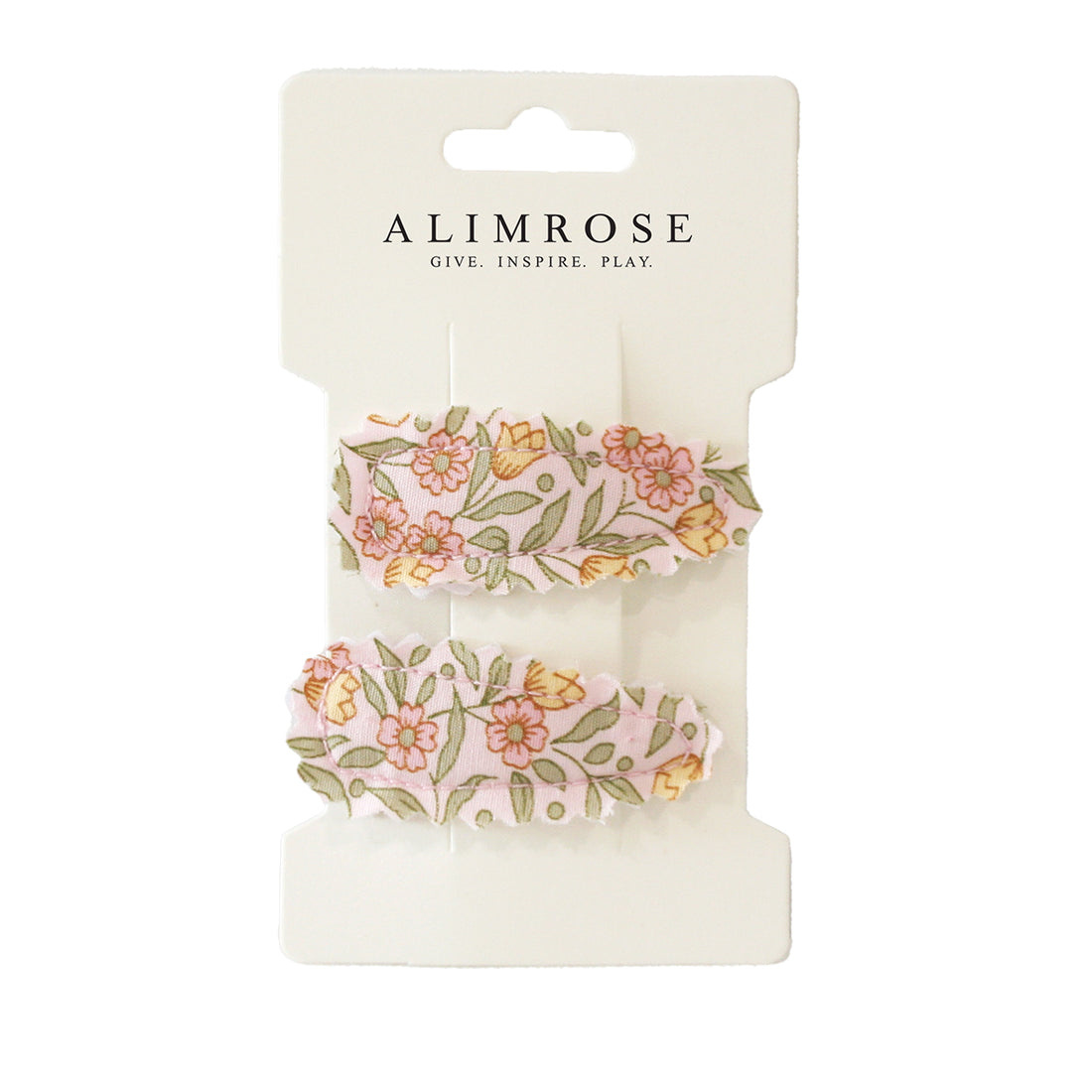 Two pink floral hair clips on a white display card.