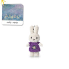 Crocheted Miffy keychain wearing a purple dress with a flower design, displayed with a Miffy-branded tag featuring a Monet painting.