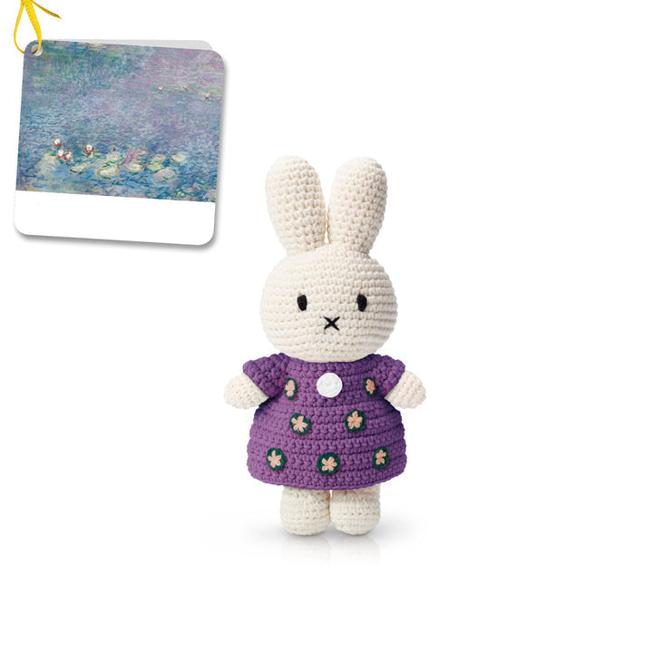 Crocheted Miffy rabbit doll in a purple flower-patterned dress.