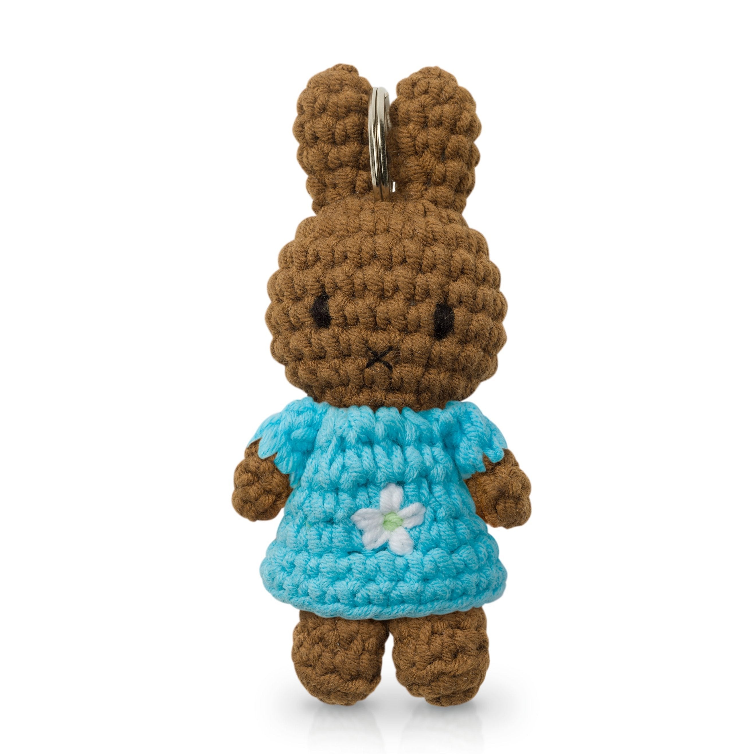 Crocheted brown bunny wearing a blue dress with a white flower.