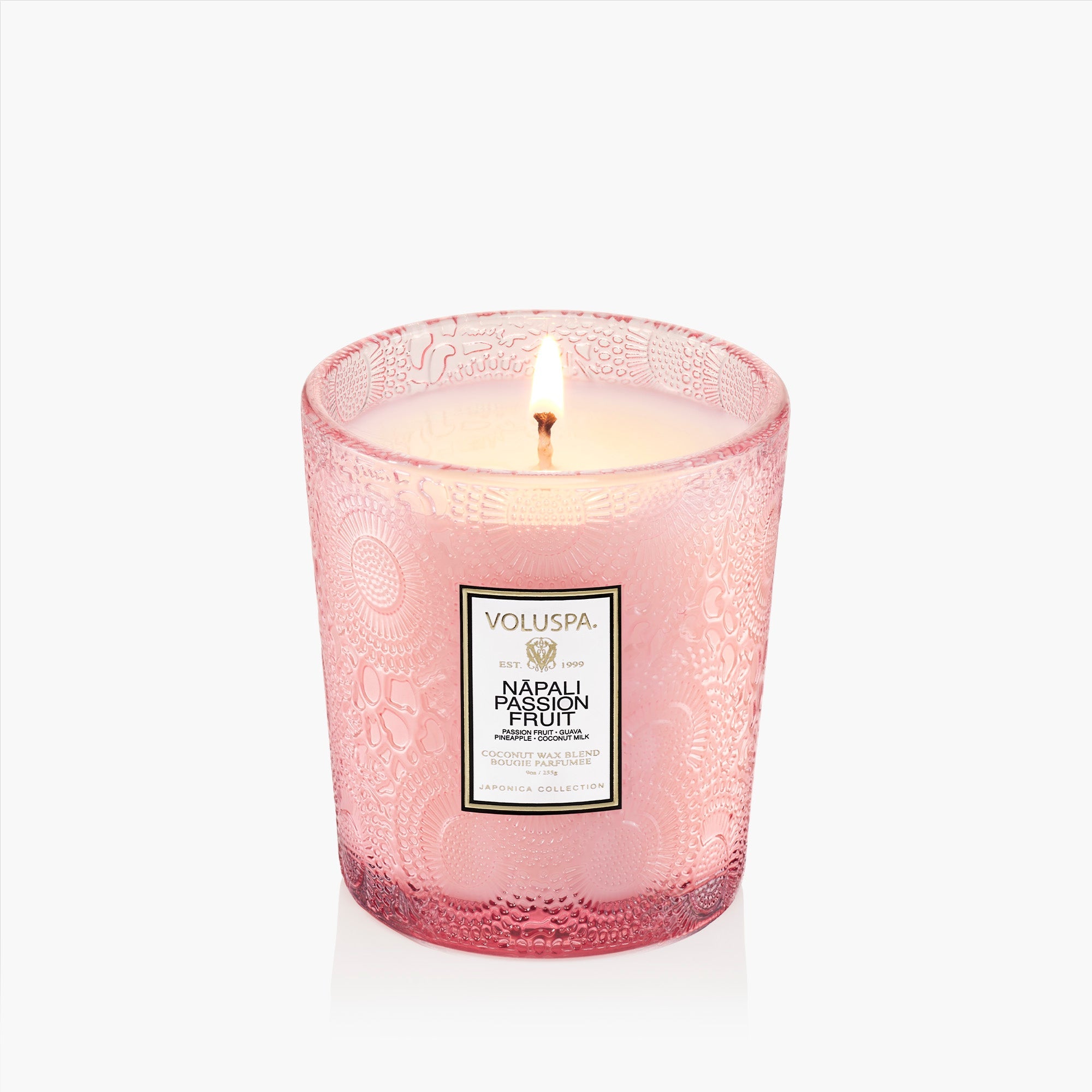 Pink Voluspa candle with a label on a white background