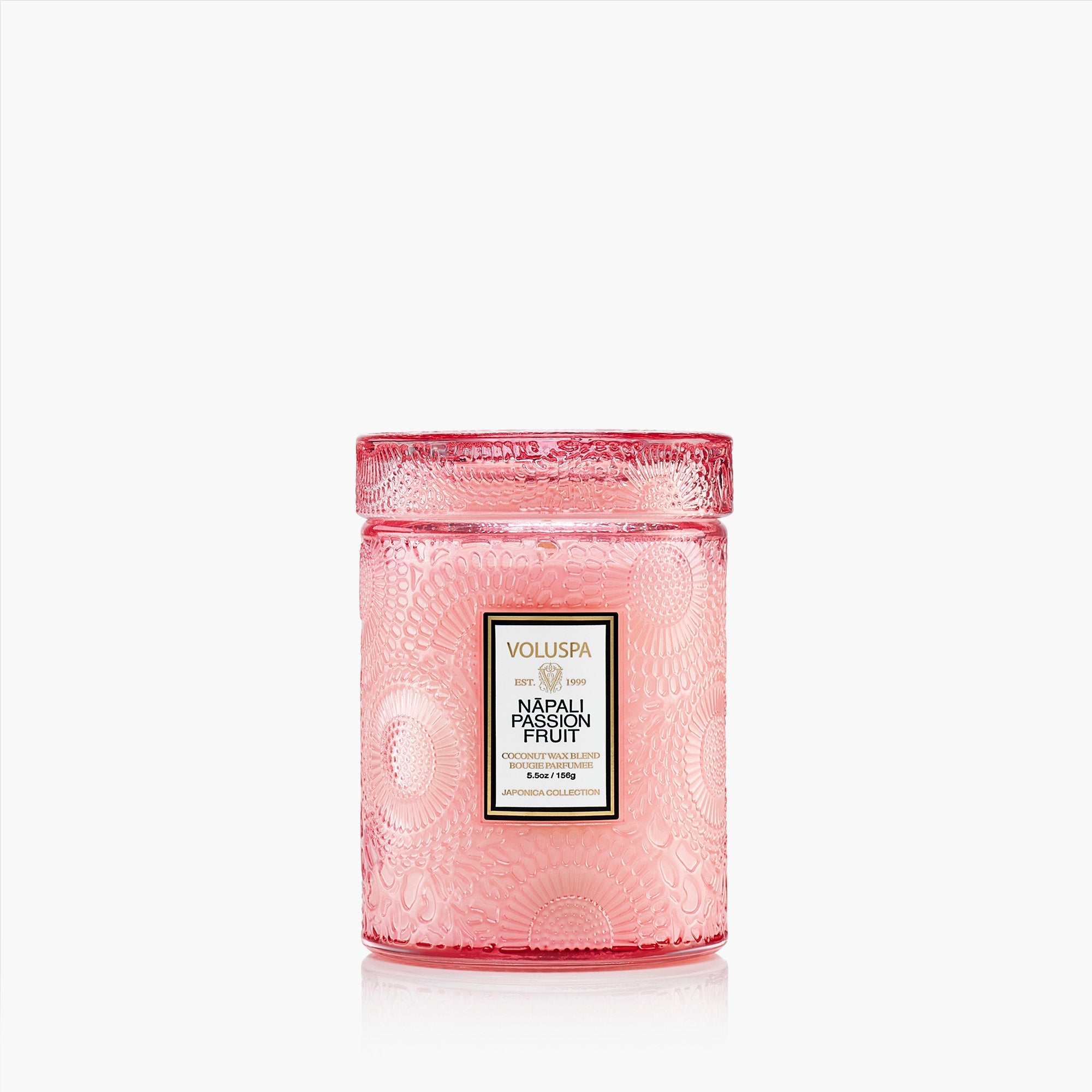 Pink candle with Voluspa label on a white background