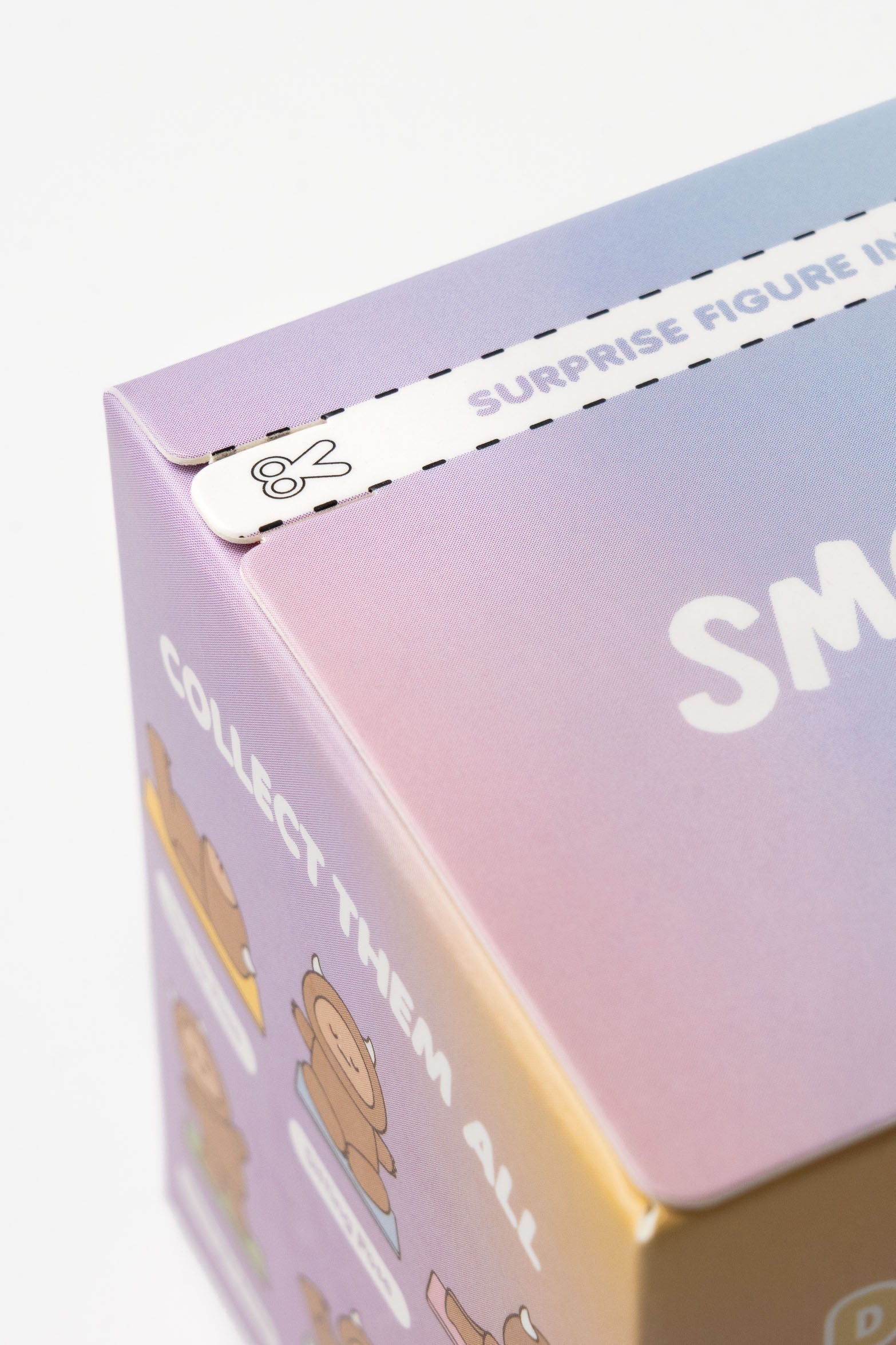 Close up of a box with scissors icon and the words "SURPRISE FIGURE IN" and "COLLECT THEM ALL."