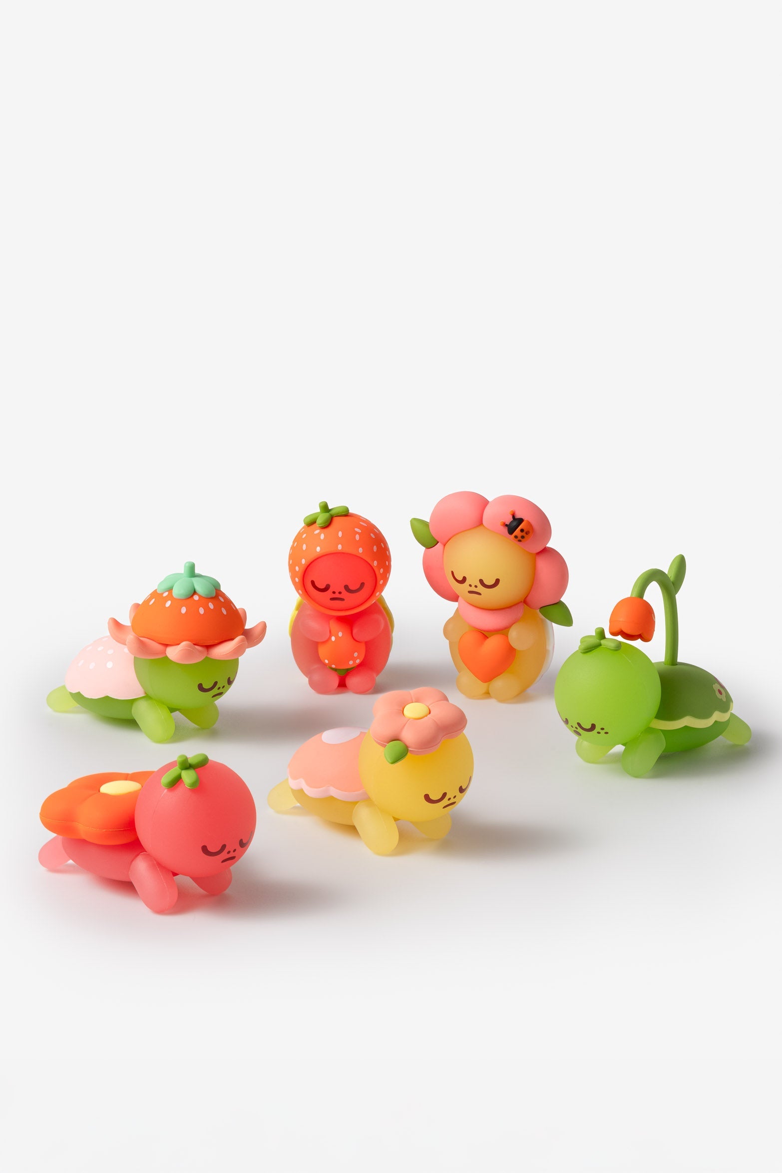 Six toy turtle figurines with fruit and flower themes.