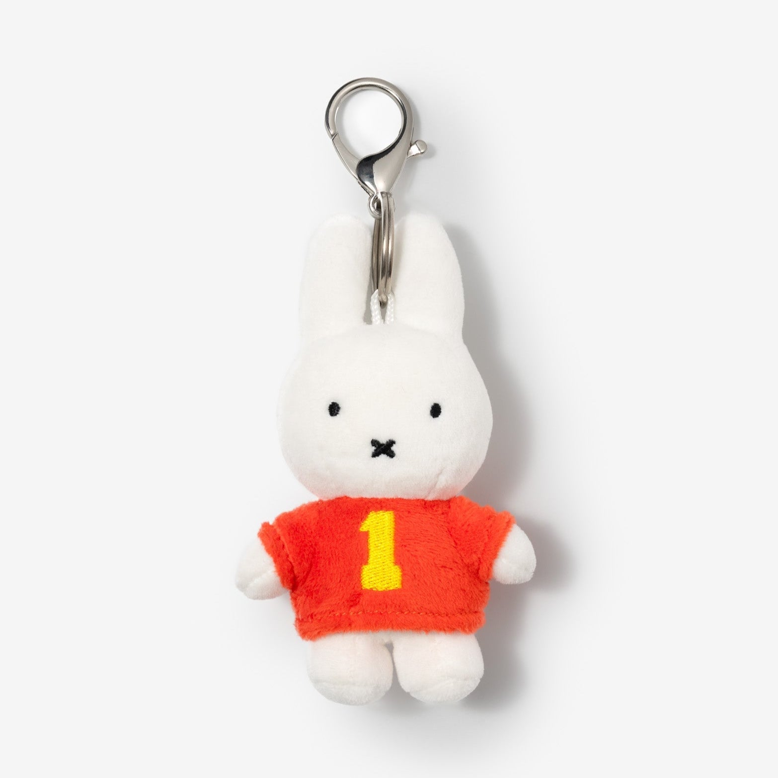 White plush Miffy rabbit keychain wearing a red jersey with a yellow number one.