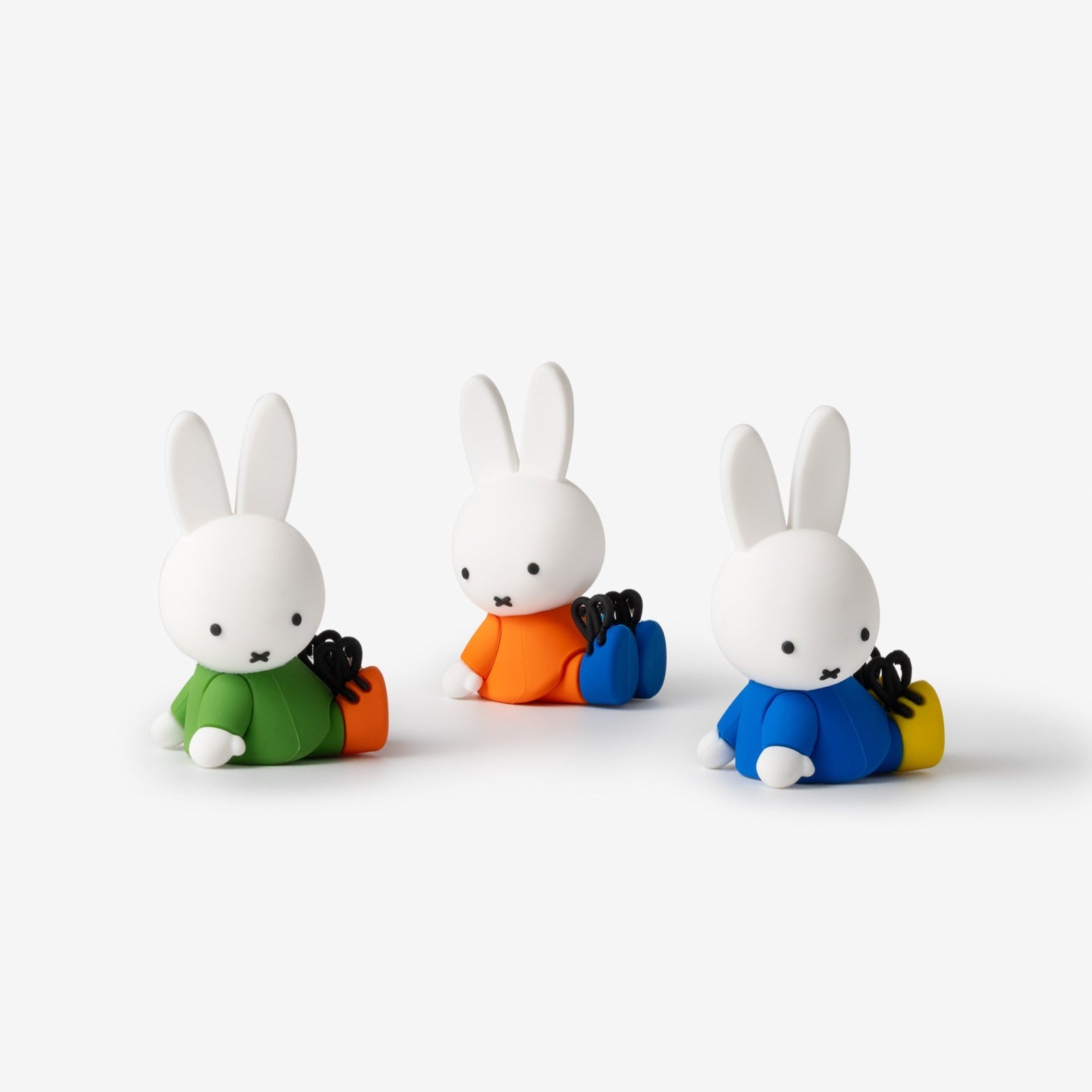 Three Miffy rabbit figurines with different colored outfits.