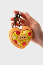 Hand holding a keychain with a heart-shaped pizza plush and keys.