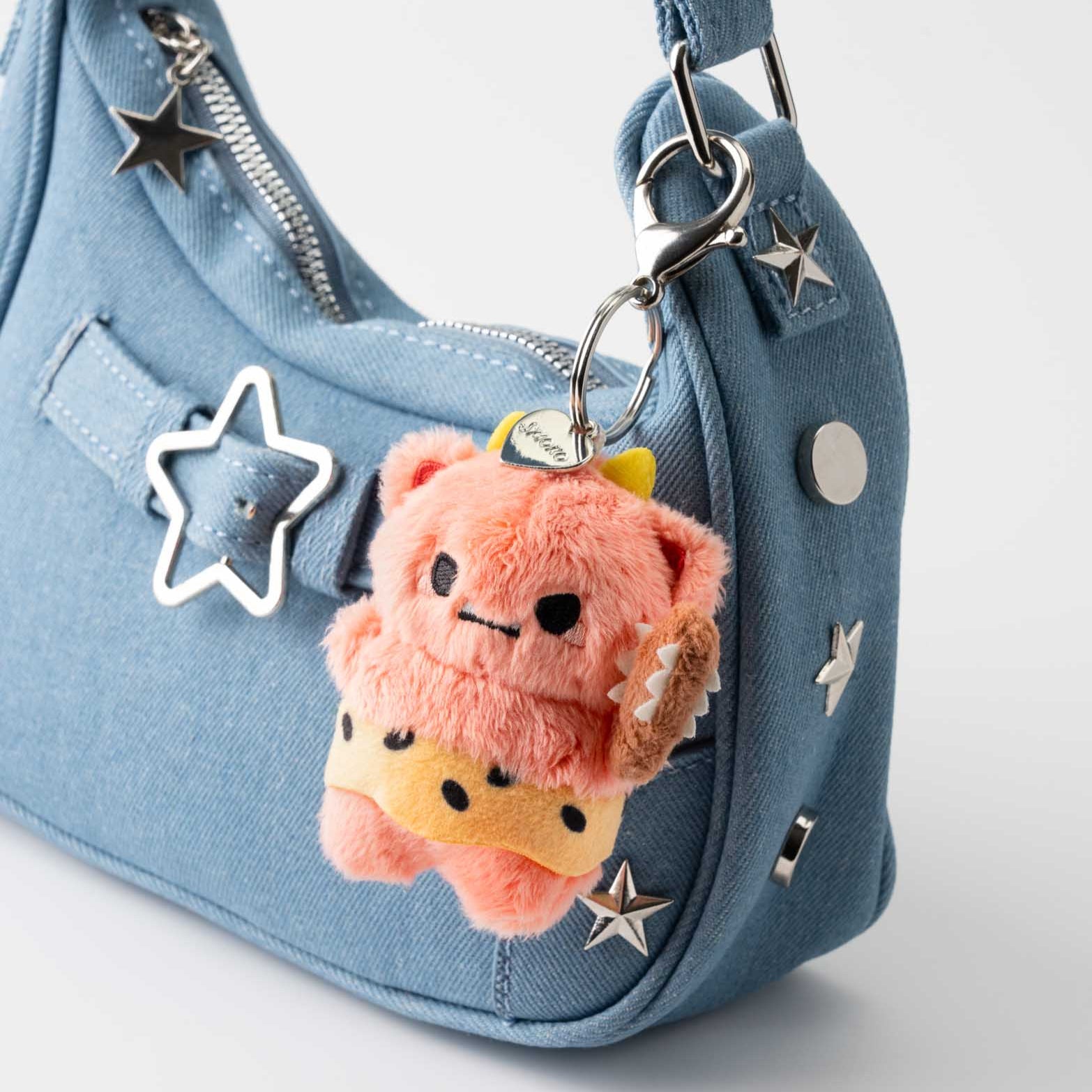 Light blue denim purse with a furry orange bear keychain.