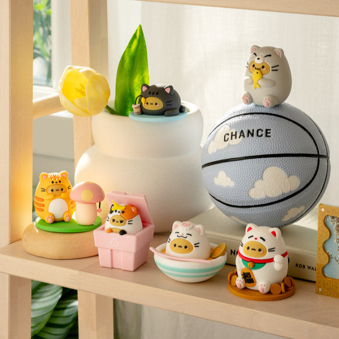 Shelf with cat figurines and a basketball.