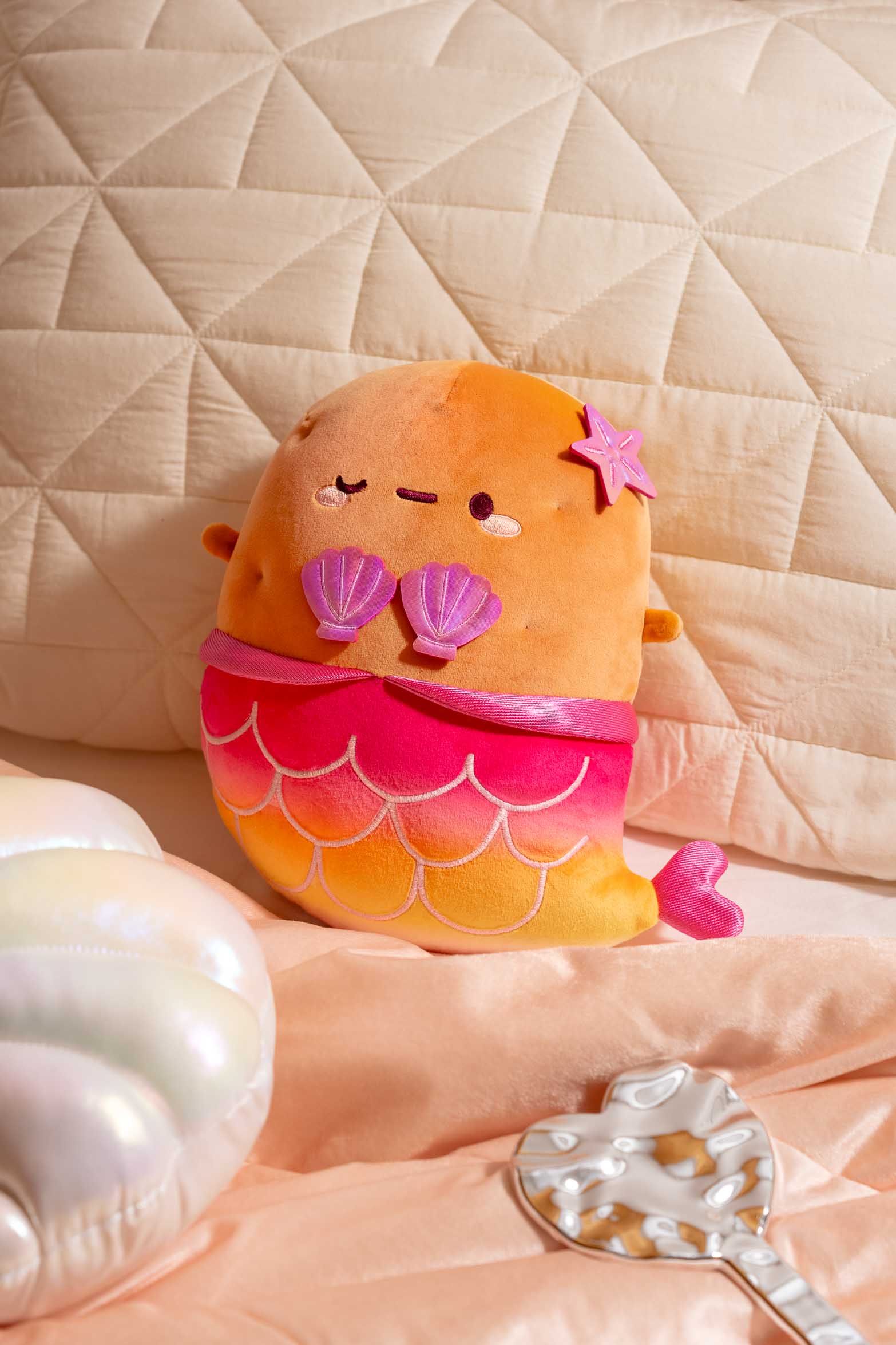 Mermaid plush toy with pink and orange ombre tail.