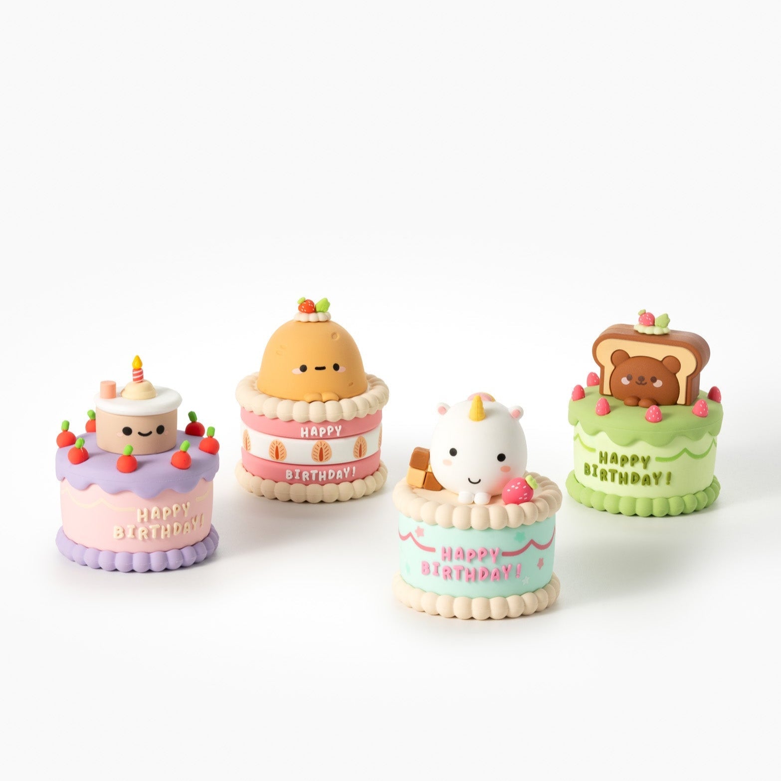 Four small cartoon birthday cakes with different animal figures on top.