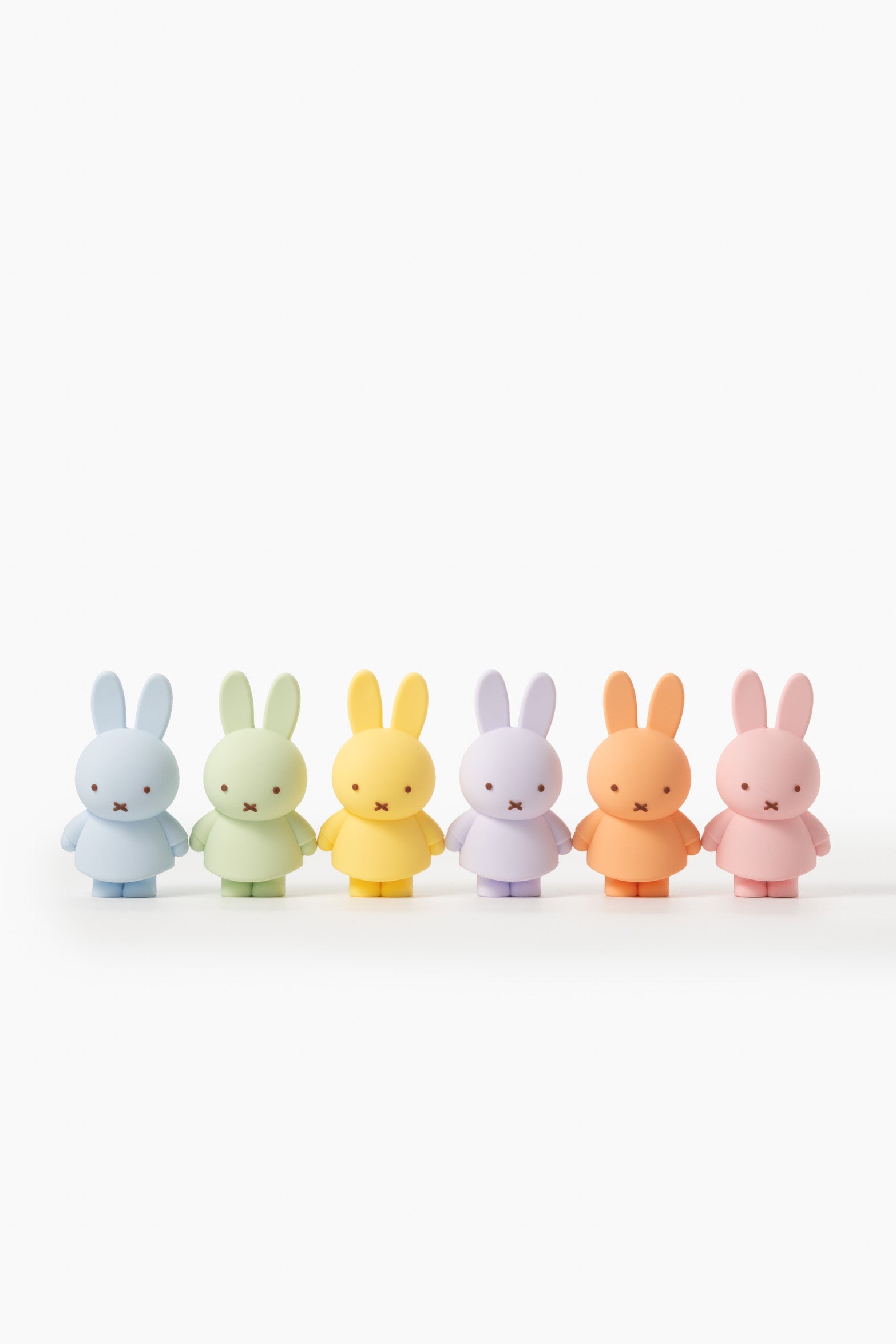 Five pastel-colored Miffy figurines standing in a row on a white background.