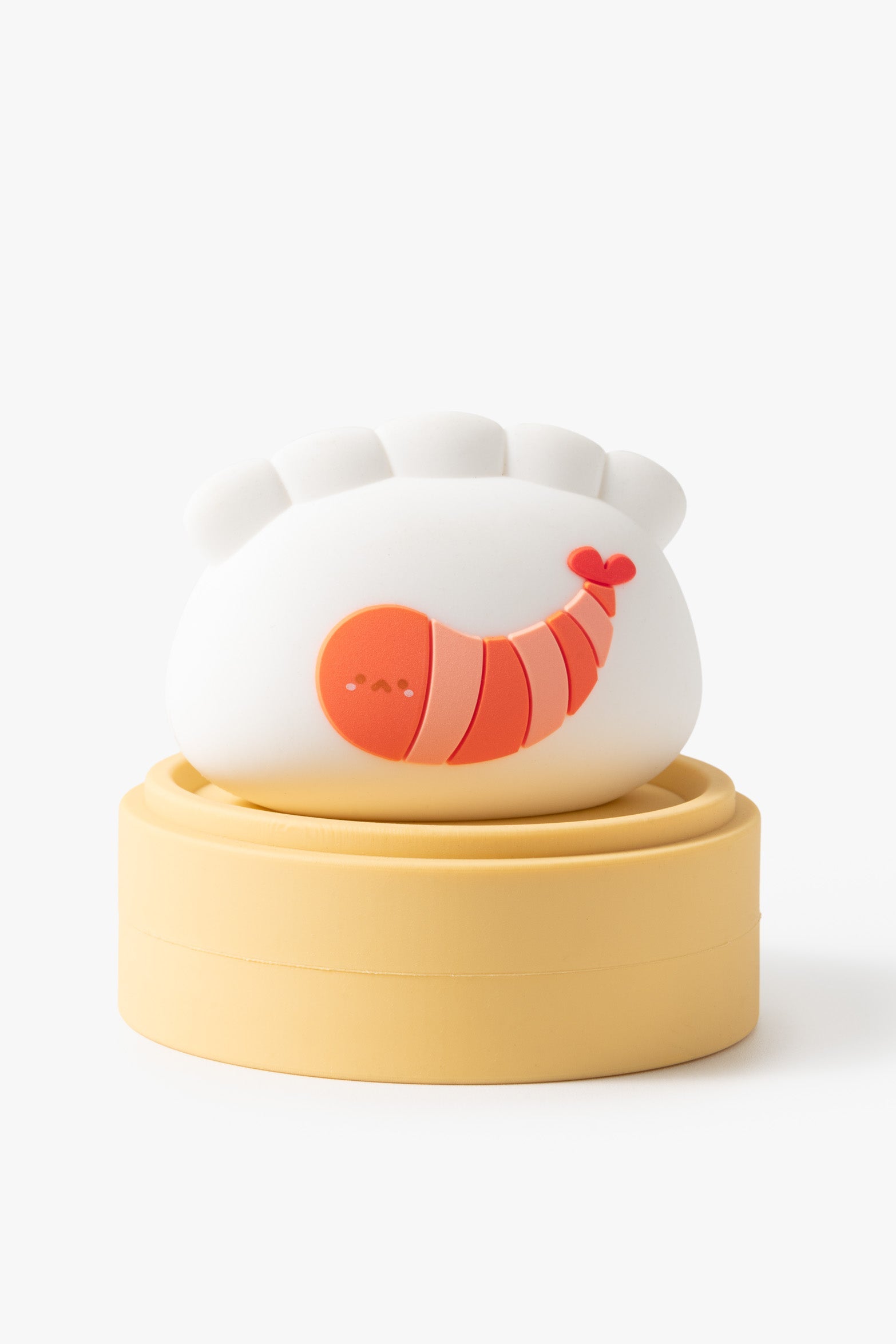 Cute cartoon dumpling with shrimp, on a yellow steamer basket.