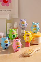 An array of colorful, bear-shaped containers with symbolic images, set among personal care products and a wooden hairbrush.