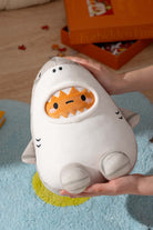 Soft, plush white and gray shark toy held in hands.