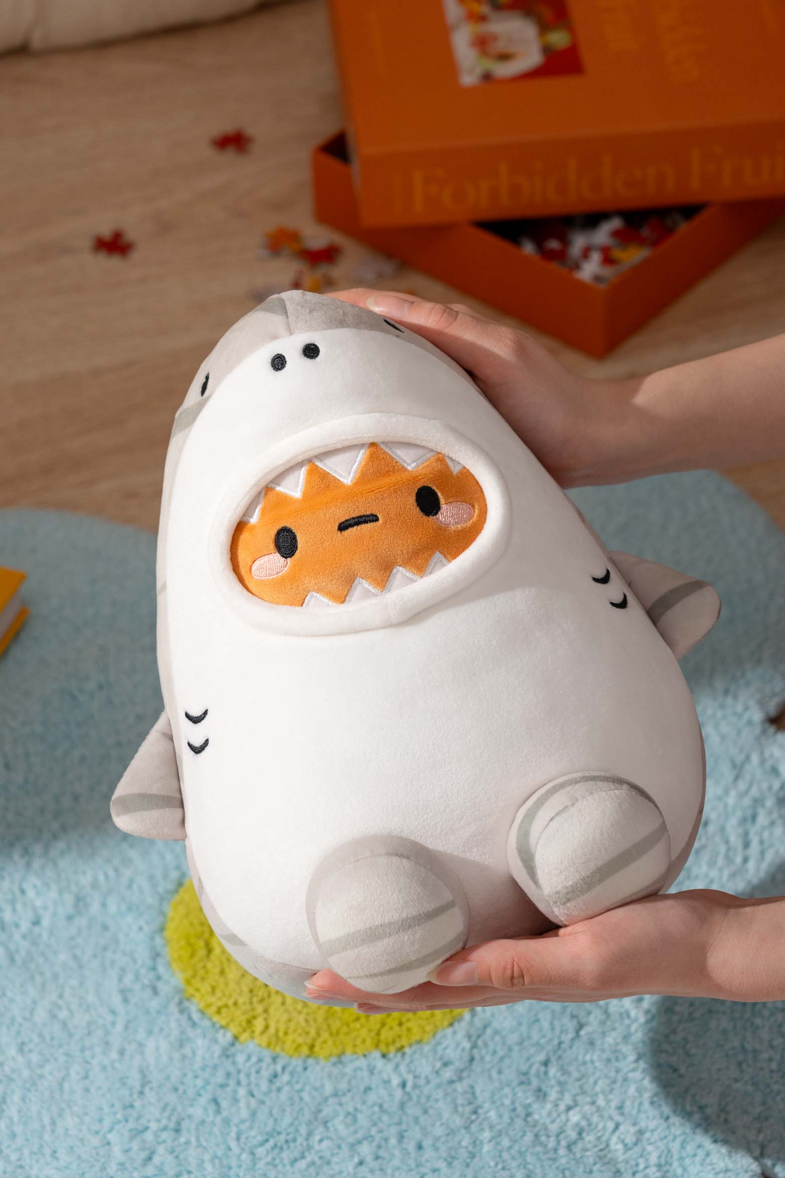 Soft, plush white and gray shark toy held in hands.