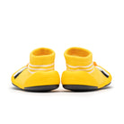 Two yellow baby sock shoes with white stripes.