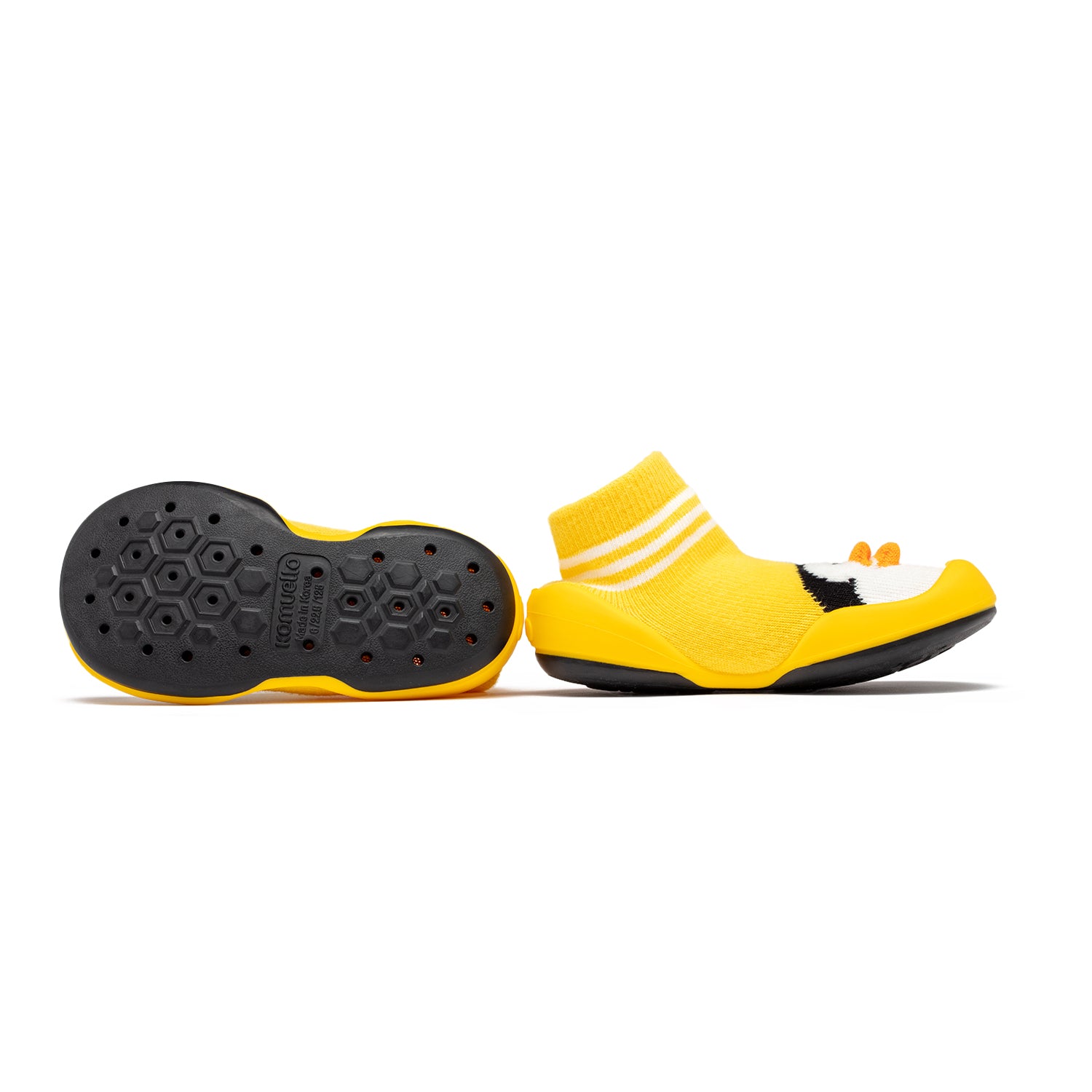Yellow sock shoes with black soles.