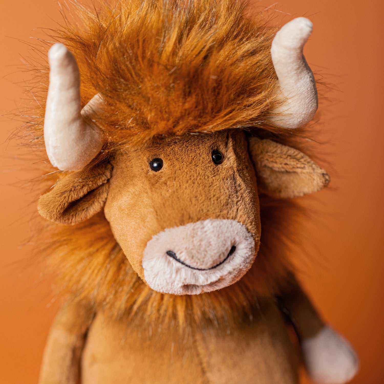 Stuffed brown bull toy with fuzzy hair.