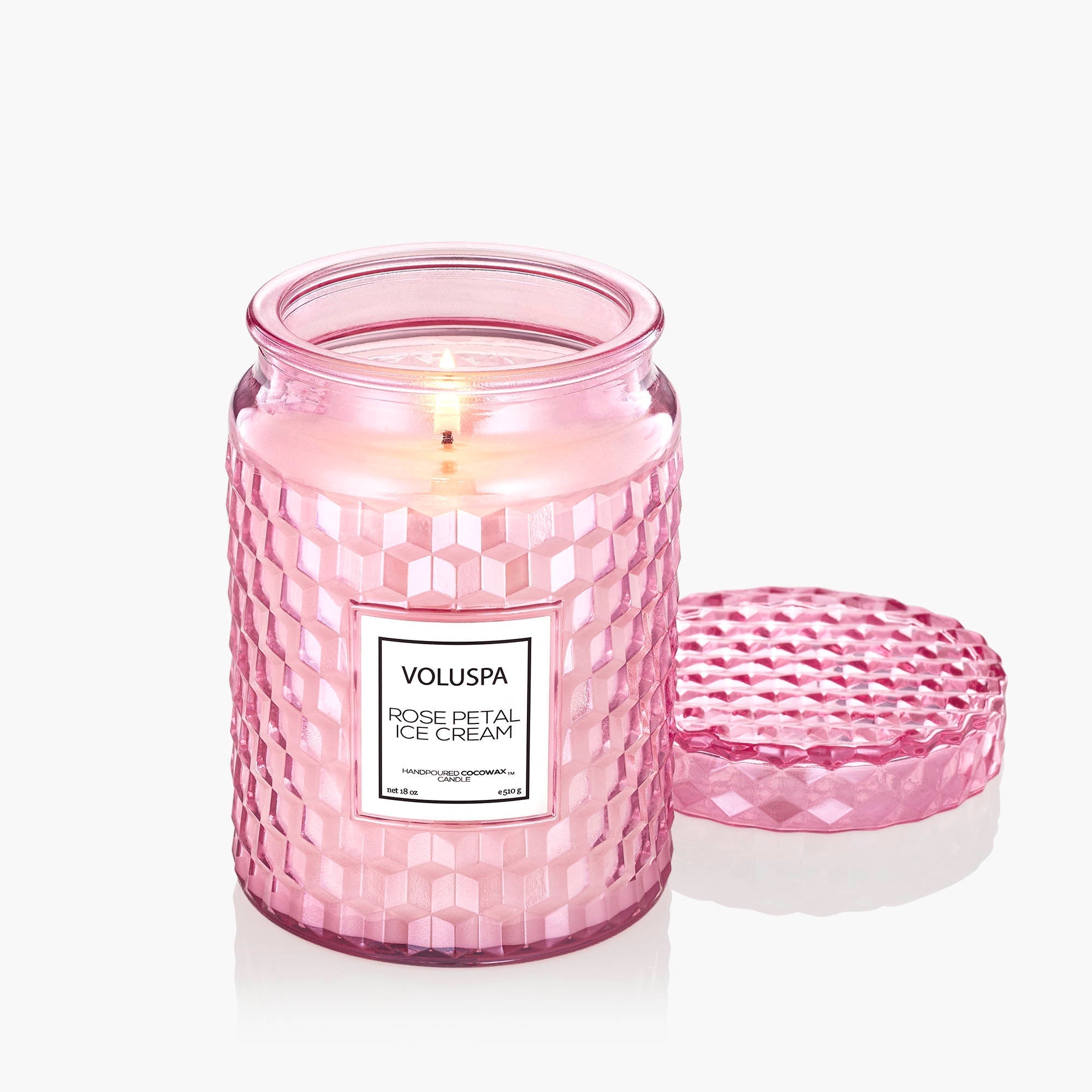 Pink Voluspa candle with a textured design on a white background