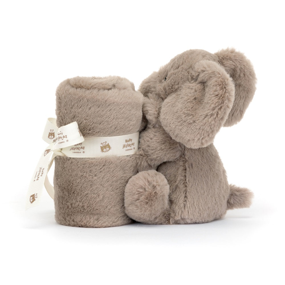 Brown plush elephant toy and rolled blanket with white ribbon.