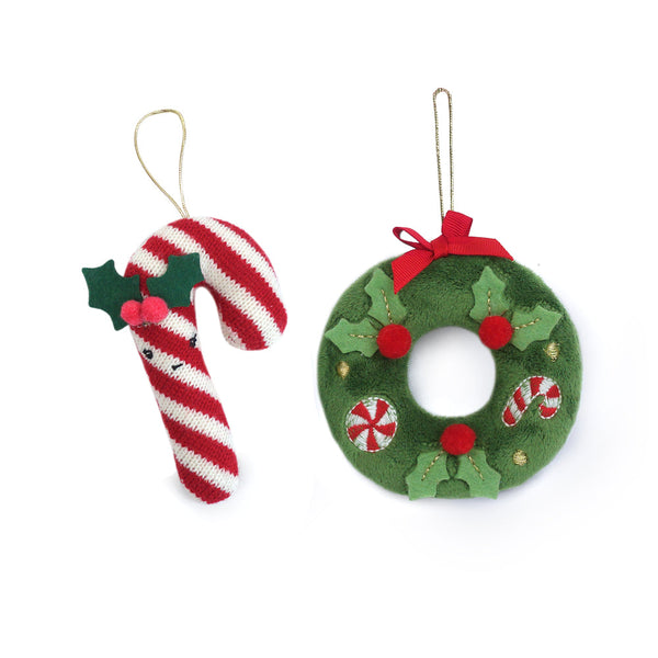 Christmas decorations: candy cane with holly and a green plush wreath.