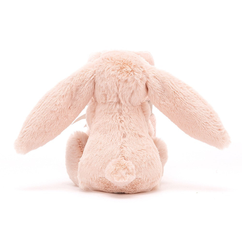 Rear view of a blush pink plush bunny with long ears.