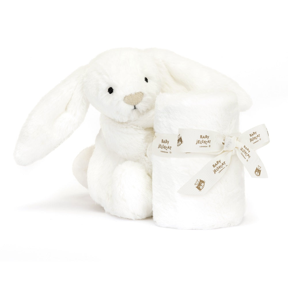 White bunny plush toy with a rolled-up blanket tied with a patterned ribbon.