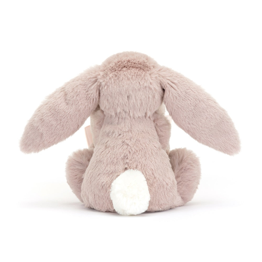 Rear view of a lavender plush bunny with long floppy ears and a fluffy white tail.