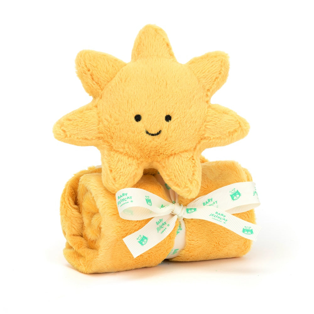 A yellow stuffed sun toy sits on top of a rolled-up yellow plush blanket tied with a white ribbon.